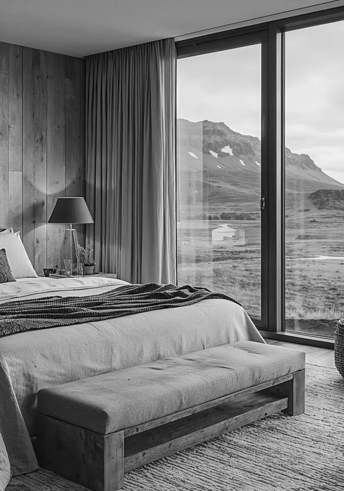 Habitación de hotel con ventanales de suelo a techo y vistas a la montaña