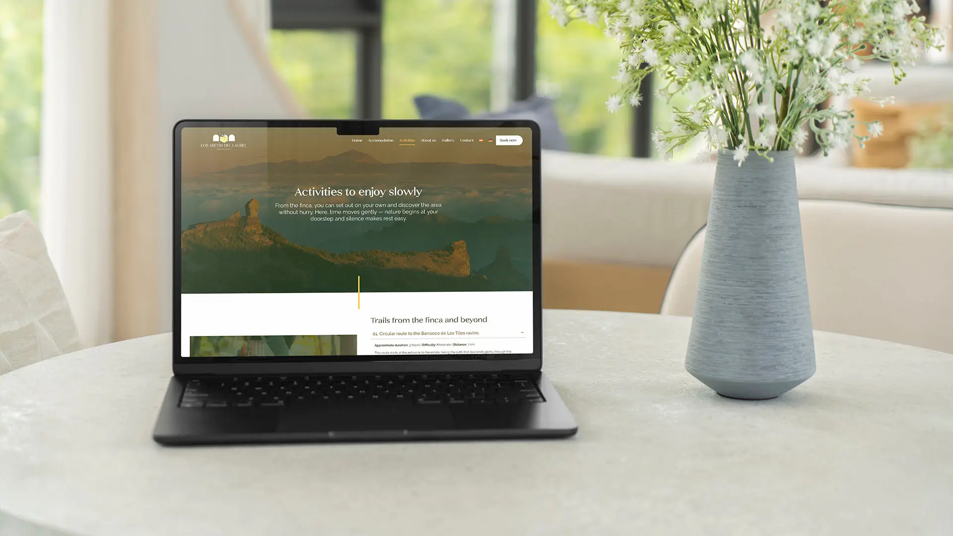 Los Arcos del Laurel website displayed on a laptop, showing the Activities page with trails and outdoor experiences from the finca